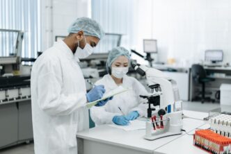 Zwei Wissenschaftler, die in einer modernen Laborumgebung an einer Forschung zusammenarbeiten und fortschrittliche Geräte verwenden.